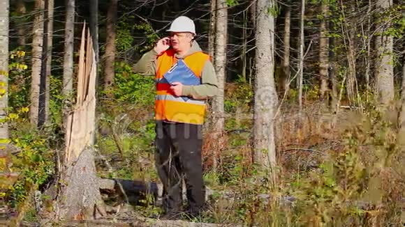 Lumberjack在被摧毁的森林里用手机聊天视频的预览图