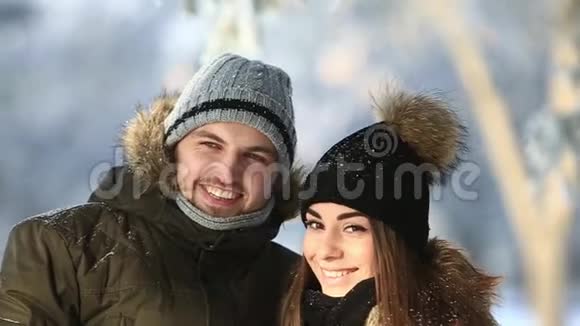 快乐的一对情侣在寒假期间一起玩耍在雪园外面度假视频的预览图
