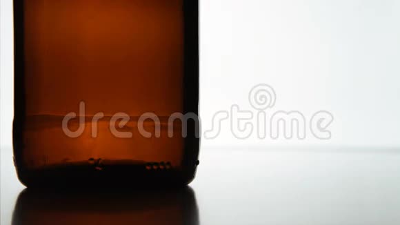 帽子落在棕色瓶子附近白色背景视频的预览图