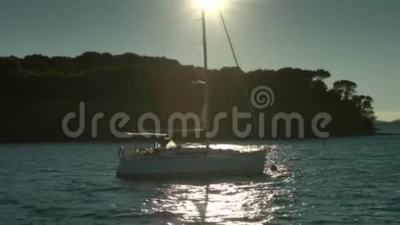 日落时帆船漂浮在海面上背景海岸线视频的预览图
