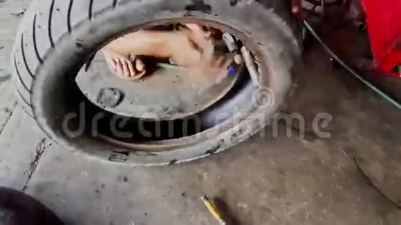 在维修车间特写男手修理滑板车车轮轮胎视频的预览图