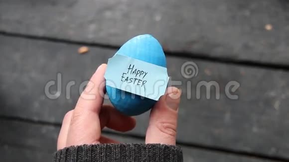 复活节快乐手拿一个有标签的鸡蛋视频的预览图