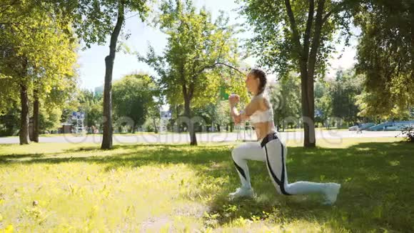 女人在户外做健身运动在绿色森林里跑马拉松之前女跑步者伸展身体斯利姆女孩视频的预览图