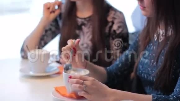 两个微笑的女朋友喝咖啡交流视频的预览图