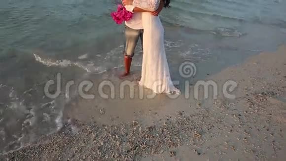 新郎新娘站在水里拥抱小岛视频的预览图