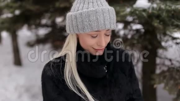 一个美丽的金发美女在冬天户外的肖像视频的预览图