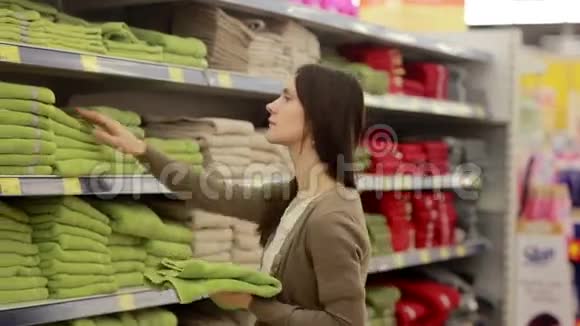 年轻女子在超市里选择毛巾视频的预览图