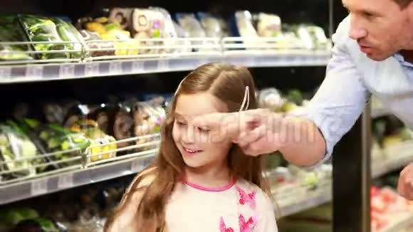 爸爸和女儿在超市里挑选沙拉视频的预览图