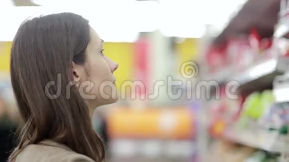 女孩选择商店货架上的商品视频的预览图