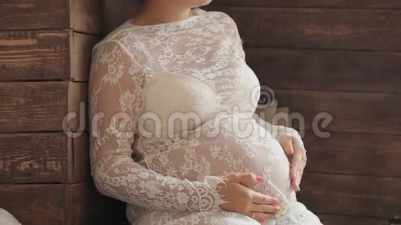 穿着漂亮衣服的孕妇靠近窗户视频的预览图