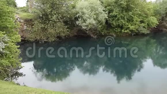 轻松观赏美丽的阿尔巴尼亚大自然绿色植物环绕的天然湖里下着小雨视频的预览图