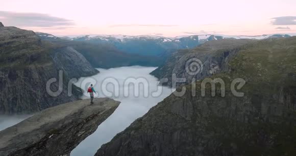 特罗隆加岩石悬崖上带背包的男子旅行者视频的预览图