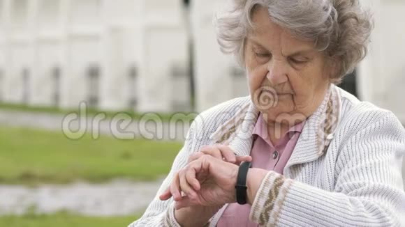 一位老妇人正在寻找腕带健身追踪器视频的预览图
