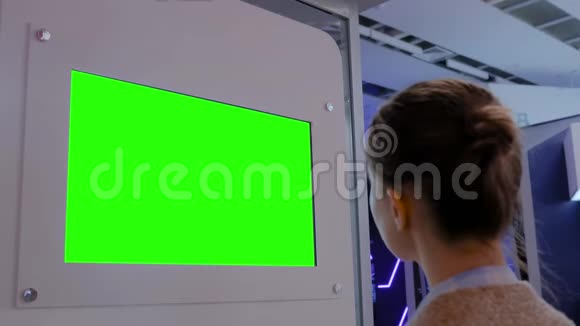 绿色屏幕概念女人看空白绿色展示墙展览视频的预览图