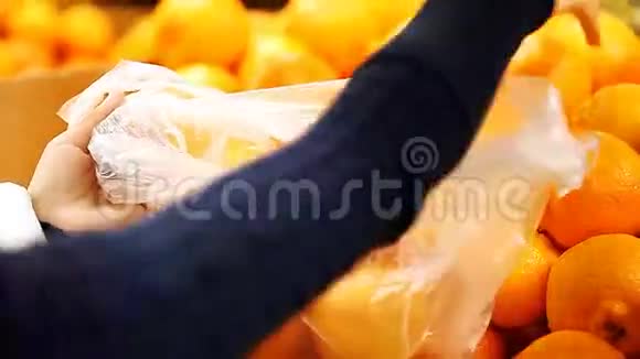 女孩在超市里选择橘子视频的预览图