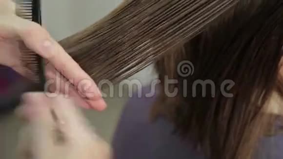 理发师用剪刀修剪棕色头发视频的预览图