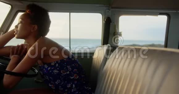 在海滩4k的露营车里放松的女人视频的预览图