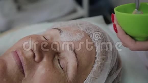 女性美容医生在美容诊所为老年妇女使用面罩视频的预览图