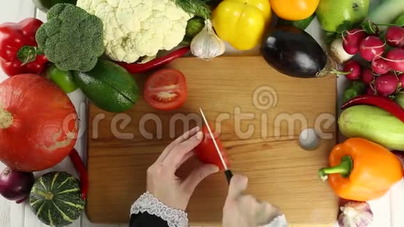 女人在新鲜蔬菜中切红番茄视频的预览图