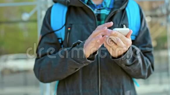 在寒冷的天气里男士双手在电话室外擦拭视频的预览图