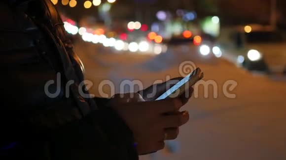 在城市的夜晚冬天的时候人们在智能手机上视频的预览图