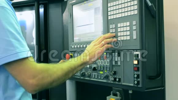 在工厂生产机器控制面板后面工作的人视频的预览图