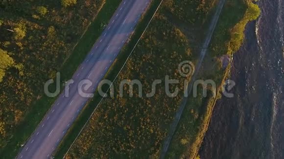 从空中俯瞰悬崖大海和公路上行驶的汽车视频的预览图