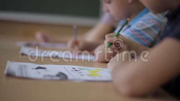 老师在课堂上帮助学校的孩子写作测试教育小学学习和人的概念视频的预览图