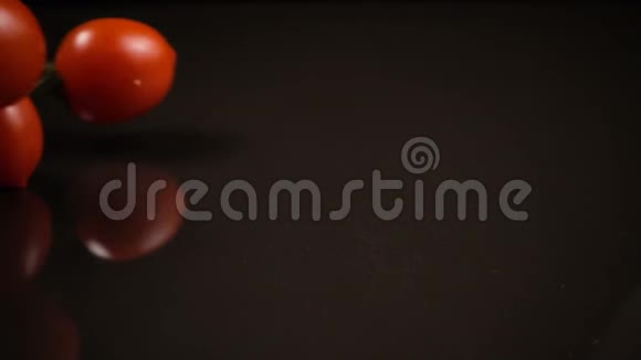黑色背景下落下的红色番茄视频的预览图