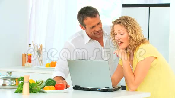 可爱的一对夫妇在网上看菜谱视频的预览图