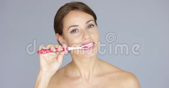 微笑着美丽的年轻女子刷牙视频的预览图