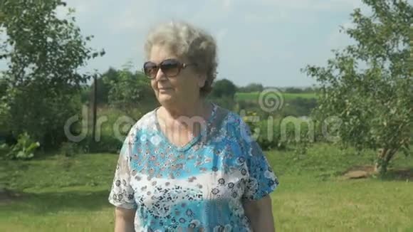 在花园公园散步的老妇人视频的预览图