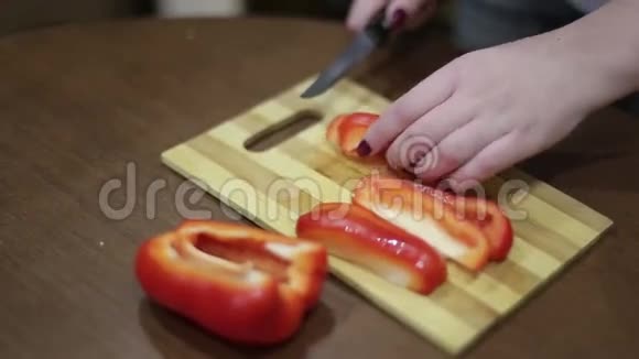 一个年轻女人在木板上切菜的手视频的预览图