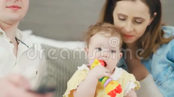 年轻幸福的家庭和一个婴儿在床上在一起幸福家庭视频的预览图