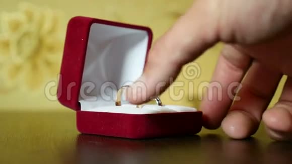 她手中的红盒子里的结婚戒指视频的预览图