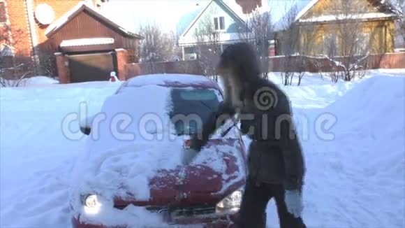 年轻女子从车里擦雪视频的预览图