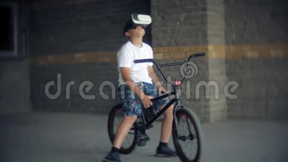 这个男孩坐在梯子上戴着虚拟眼镜旁边是自行车BMX视频的预览图