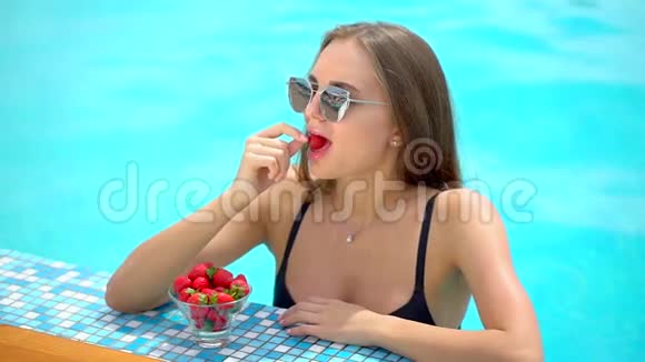 夏天美丽的年轻女子比基尼女孩在热带游泳池放松喝新鲜鸡尾酒的女人视频的预览图