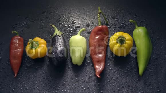 蔬菜茄子和胡椒在黑暗的水面上滴着水珠视频的预览图