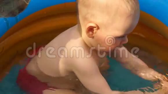 幼儿男孩在游泳池游泳玩鱼玩具视频的预览图