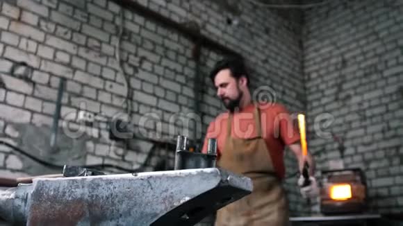 肌肉男铁匠用铁锤锻造钢刀视频的预览图
