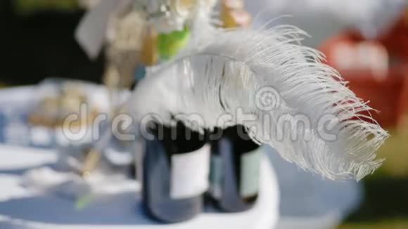 几瓶香槟和羽毛放在桌上视频的预览图