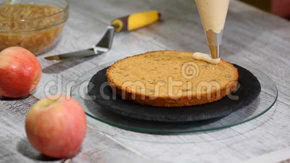在厨房做焦糖苹果蛋糕厨师用带奶油的糕点包装饰视频的预览图