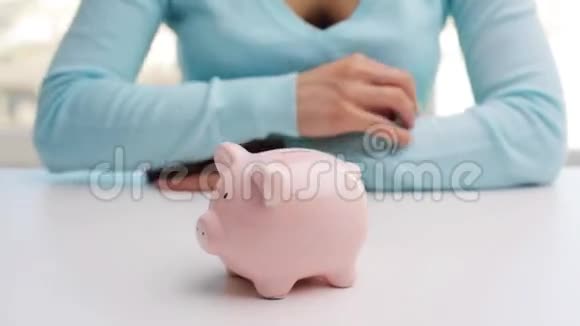 女人把一枚欧元硬币放进储蓄罐视频的预览图