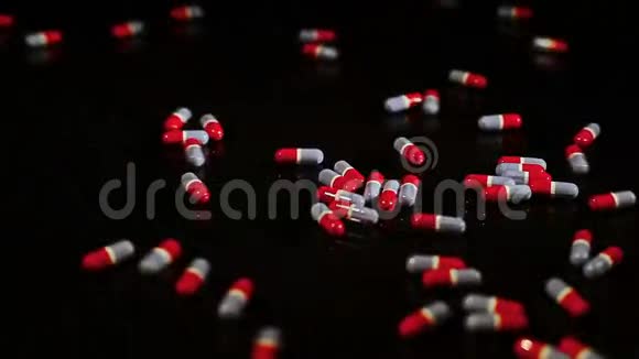 药丸胶囊滑动在黑色玻璃上视频的预览图