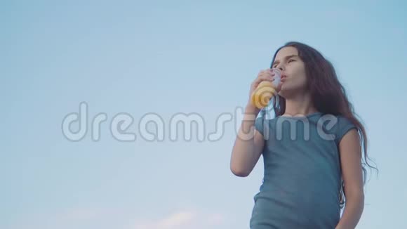 小女孩喝塑料瓶慢动作视频青少年喝果汁和水运动聪明视频的预览图