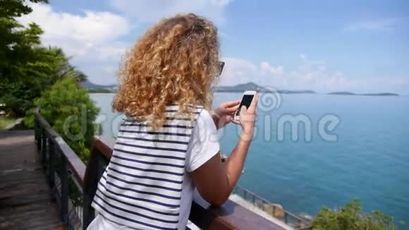 青少年使用智能手机欣赏海景视频的预览图