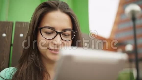 优雅的年轻女孩使用迷你平板戴眼镜的漂亮学生视频的预览图