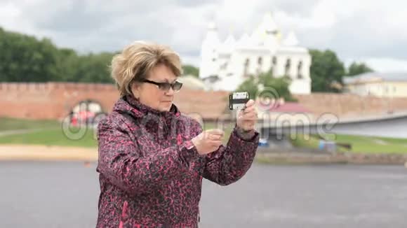 成年妇女使用银色智能手机拍照视频的预览图