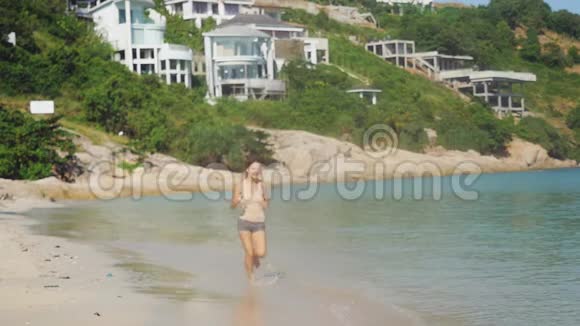 美丽苗条的黑发女孩在热带海滩上缓慢地奔跑1920x1080视频的预览图